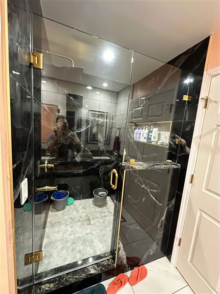 Glass shower black marble tile gold hardware completed by NG Construction & Improvements
