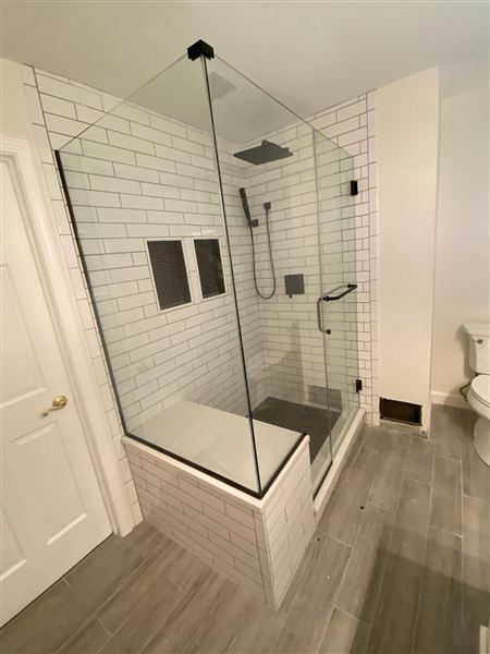 Glass shower enclosure white subway tiles completed by NG Construction & Improvements