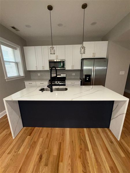 Dark island white quartz waterfall countertop completed by NG Construction & Improvements