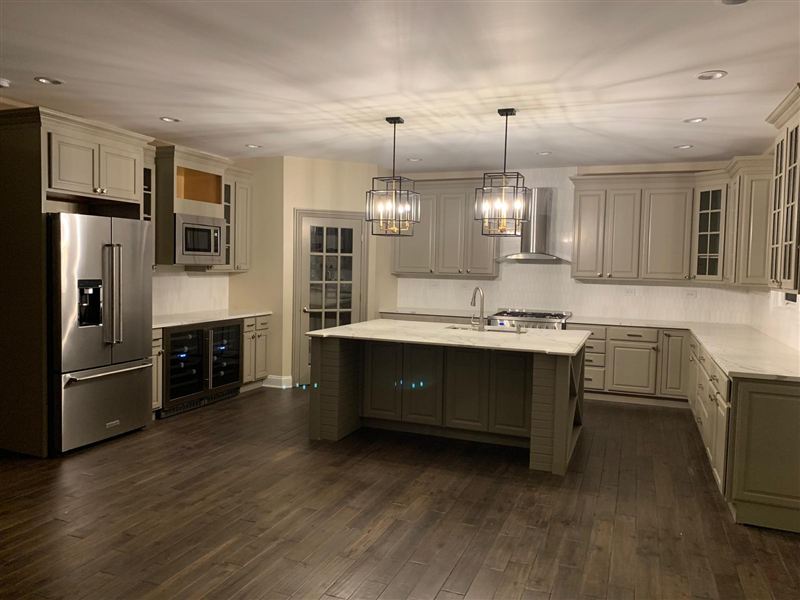 Sage green cabinets marble countertops pendant lights completed by NG Construction & Improvements