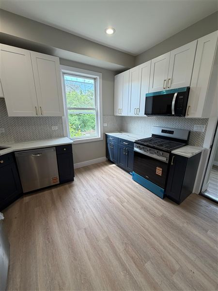 Blue lower cabinets herringbone backsplash completed by NG Construction & Improvements